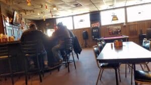 People sitting at a bar in a restaurant with their backs to the camera