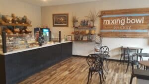 Bakery Counter with Glass Case containing baked goods and small table & chairs