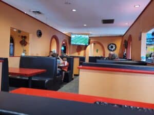 Brightly Colored Mexican Restaurant with booths & TV in the background